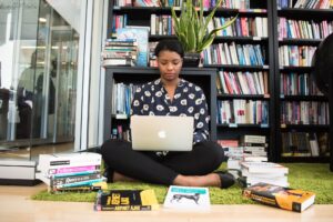 Worker researching with books and laptop